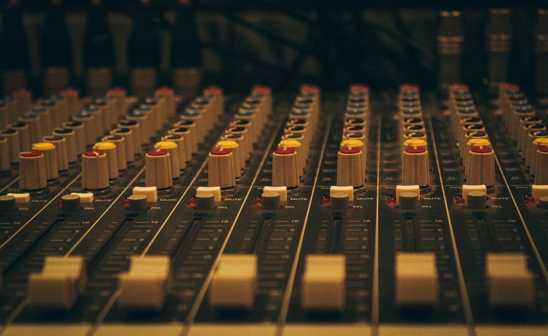 Close-up of an audio mixing console with faders